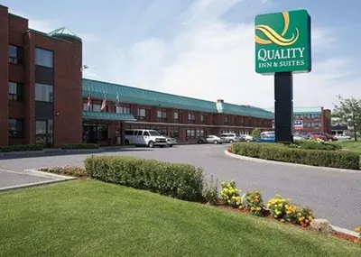 a building with a sign in front of it at Quality Inn & Suites PE Trudeau Airport in Dorval