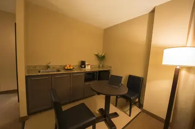 a small kitchen with a table with a laptop on it at Quality Inn & Suites PE Trudeau Airport in Dorval
