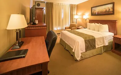 a hotel room with a bed and a desk at Quality Inn & Suites PE Trudeau Airport in Dorval