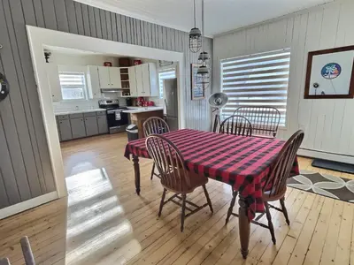 a kitchen and dining room with a table and chairs at Bel appartement A la croisée des sommets in Notre-Dame-Des-Bois