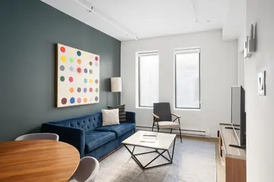 a living room with a blue couch and a table at Bakan- Quartier des Congres, Convention District in Montréal