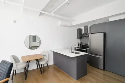 a kitchen with a sink and a refrigerator at Bakan- Quartier des Congres, Convention District in Montréal