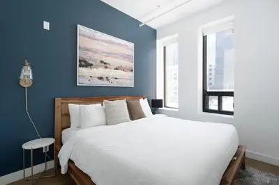 a bedroom with a white bed and blue walls at Bakan- Quartier des Congres, Convention District in Montréal