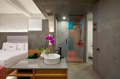a bedroom with a white bed and a bathroom at David Hotel in Montréal
