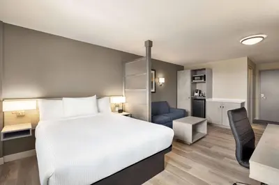 a hotel room with a bed and a desk and a chair at Microtel Inn & Suites Dorval QC in Dorval