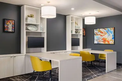 a dining room with a white table and yellow chairs at Microtel Inn & Suites Dorval QC in Dorval
