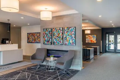 a lobby with chairs and paintings on the wall at Microtel Inn & Suites Dorval QC in Dorval