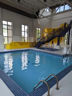 a large indoor swimming pool with a slide at Microtel Inn & Suites Dorval QC in Dorval