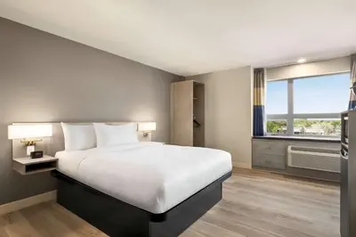 a bedroom with a large bed and a window at Microtel Inn & Suites Dorval QC in Dorval