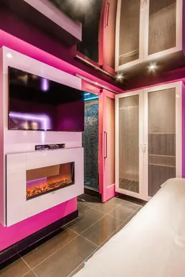a living room with a fireplace and pink walls at Olux Hotel-Motel-Suites in Laval