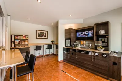a living room with a kitchen and a bar at Olux Hotel-Motel-Suites in Laval