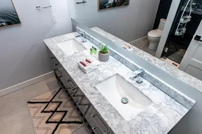 a bathroom with two sinks and a mirror at Vast and perfectly located 3 bedroom flat by DenStays in Montréal