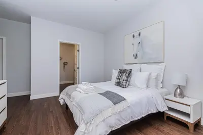 a white bedroom with a large bed with white pillows at Vast and perfectly located 3 bedroom flat by DenStays in Montréal