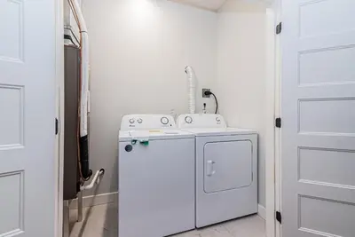 a kitchen with a washing machine on top of a refrigerator at Vast and perfectly located 3 bedroom flat by DenStays in Montréal