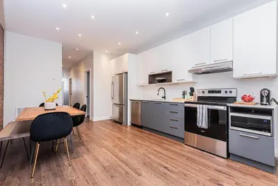 a kitchen with a wooden table and a wooden floor at Vast and perfectly located 3 bedroom flat by DenStays in Montréal