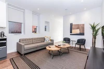 a living room with a couch and a table at Vast and perfectly located 3 bedroom flat by DenStays in Montréal