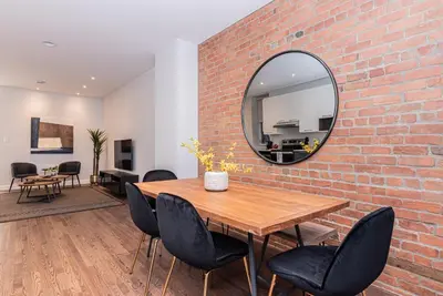 a dining room with a brick wall and a mirror at Vast and perfectly located 3 bedroom flat by DenStays in Montréal
