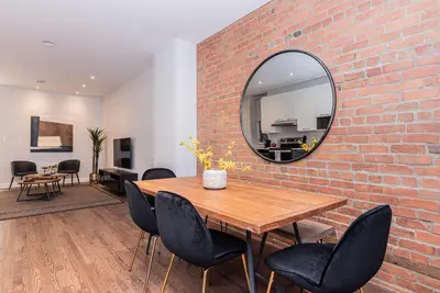 a dining room with a brick wall and a mirror at Vast and perfectly located 3 bedroom flat by DenStays in Montréal