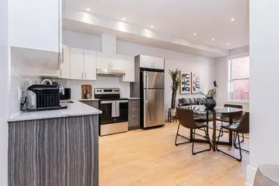 a kitchen and dining room with a table and refrigerator at New classy 2 bedroom apartment in Le Plateau by DenStays in Montréal