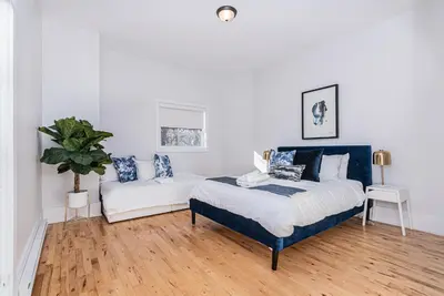 a bedroom with a king sized bed and a couch at Welcoming and Homey unit near Mount Royal by DenStays in Montréal