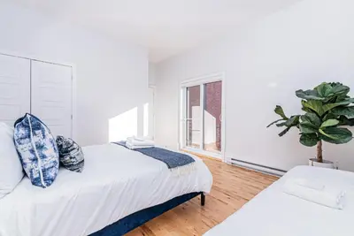 a bedroom with two beds and a potted plant at Welcoming and Homey unit near Mount Royal by DenStays in Montréal