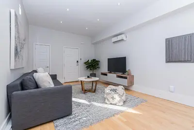 a living room with a couch and a tv at Welcoming and Homey unit near Mount Royal by DenStays in Montréal