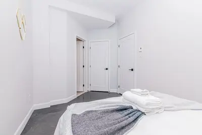 a white bedroom with a bed with towels on it at Massive 3 bedroom apartment in the hearth of Le Plateau by DenStays in Montréal