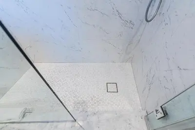 a shower with a glass door and a white tile floor at Massive 3 bedroom apartment in the hearth of Le Plateau by DenStays in Montréal