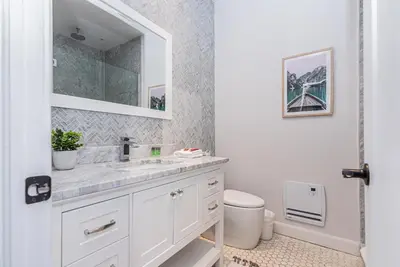 a white bathroom with a sink and a mirror at Massive 3 bedroom apartment in the hearth of Le Plateau by DenStays in Montréal