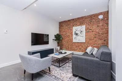 a living room with two couches and a brick wall at Massive 3 bedroom apartment in the hearth of Le Plateau by DenStays in Montréal