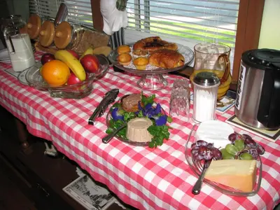 a table with food on a red and white checked table cloth at Magnolia B&B in Granby