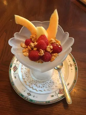 a bowl of fruit with bananas and strawberries on a plate at Magnolia B&B in Granby