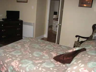 a bedroom with a bed and a dresser with a flowered blanket at Magnolia B&B in Granby