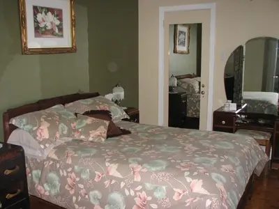 a bedroom with a bed with a flowered blanket at Magnolia B&B in Granby
