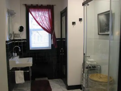 a bathroom with a sink and a shower with a window at Magnolia B&B in Granby