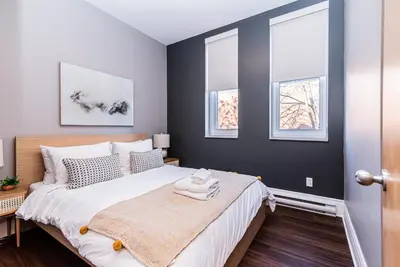 a bedroom with a bed and three windows at Family Friendly 3-bedroom beauty in Le Plateau by DenStays in Montréal