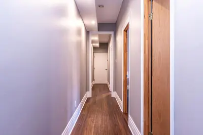 a hallway of an apartment with white walls and wooden floors at Family Friendly 3-bedroom beauty in Le Plateau by DenStays in Montréal