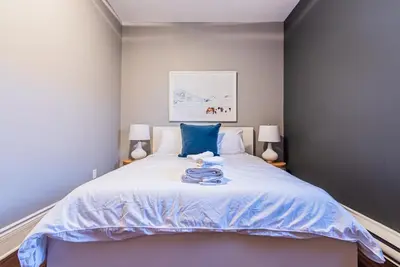a bedroom with a bed with blue sheets and two lamps at Family Friendly 3-bedroom beauty in Le Plateau by DenStays in Montréal