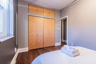 a bedroom with a bed and a wooden cabinet at Family Friendly 3-bedroom beauty in Le Plateau by DenStays in Montréal