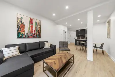 a living room with a black couch and a table at Stonewall Suites in Montréal