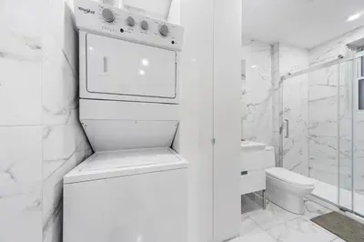 a white bathroom with a stove and a toilet at Stonewall Suites in Montréal