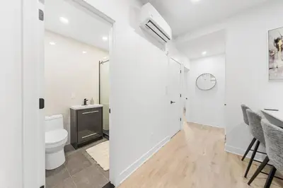 a white bathroom with a toilet and a sink at Stonewall Suites in Montréal