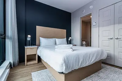 a bedroom with a large bed with blue walls at WERFY Luxury Apart-Hotel in Montréal