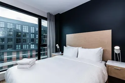 a bedroom with a large bed and a large window at WERFY Luxury Apart-Hotel in Montréal