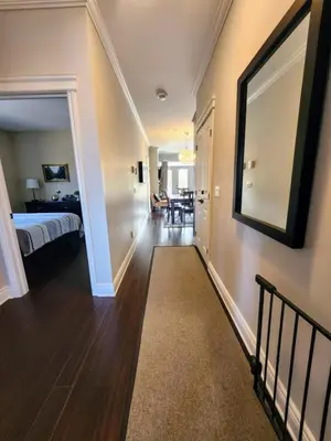 a hallway leading to a bedroom with a bed and a mirror at Le 201 Champlain Bromont in Bromont