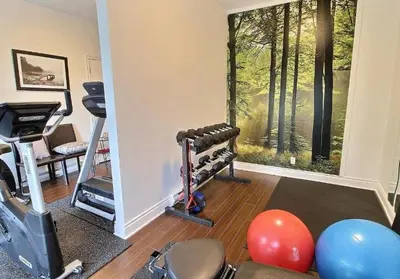 a room with a gym with exercise equipment and a window at Le 201 Champlain Bromont in Bromont