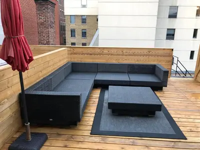 a patio with two benches and an umbrella at Suites De la Montagne in Montréal