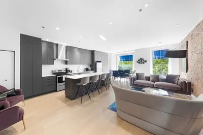 a kitchen and living room with a couch and a bar at Suites De la Montagne in Montréal