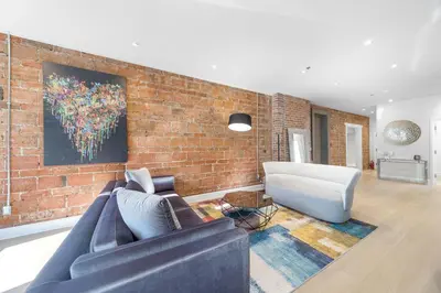 a living room with two couches and a brick wall at Suites De la Montagne in Montréal