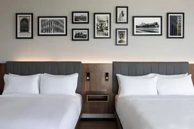 two beds in a room with pictures on the wall at Hyatt Centric Montreal in Montréal